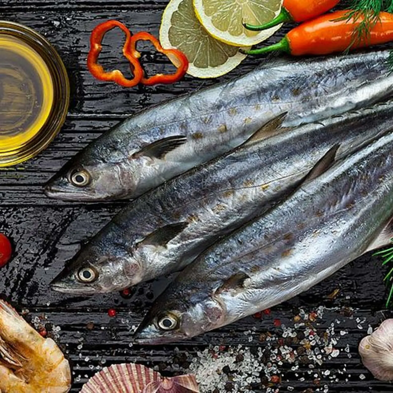 Frischer Fisch angerichtet mit verschiedenen Zutaten auf Tischplatte