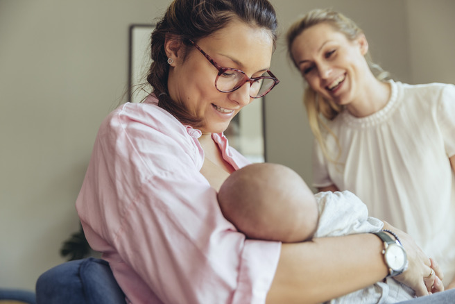 Frau hält Baby und lächelt