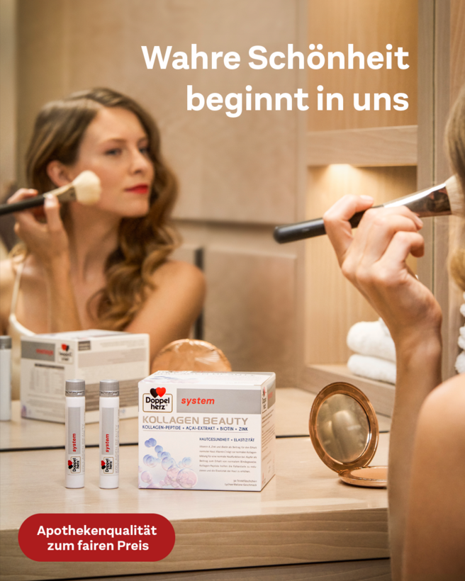 Eine Frau sitzt am Schminkspiegel und trägt Puder auf. Vor ihr steht eine Box mit dem Produkt "Kollagen Beauty" und daneben zwei Tuben. Der Text "Wahre Schönheit beginnt in uns" ist sichtbar. Der Hintergrund zeigt eine helle, moderne Umgebung.