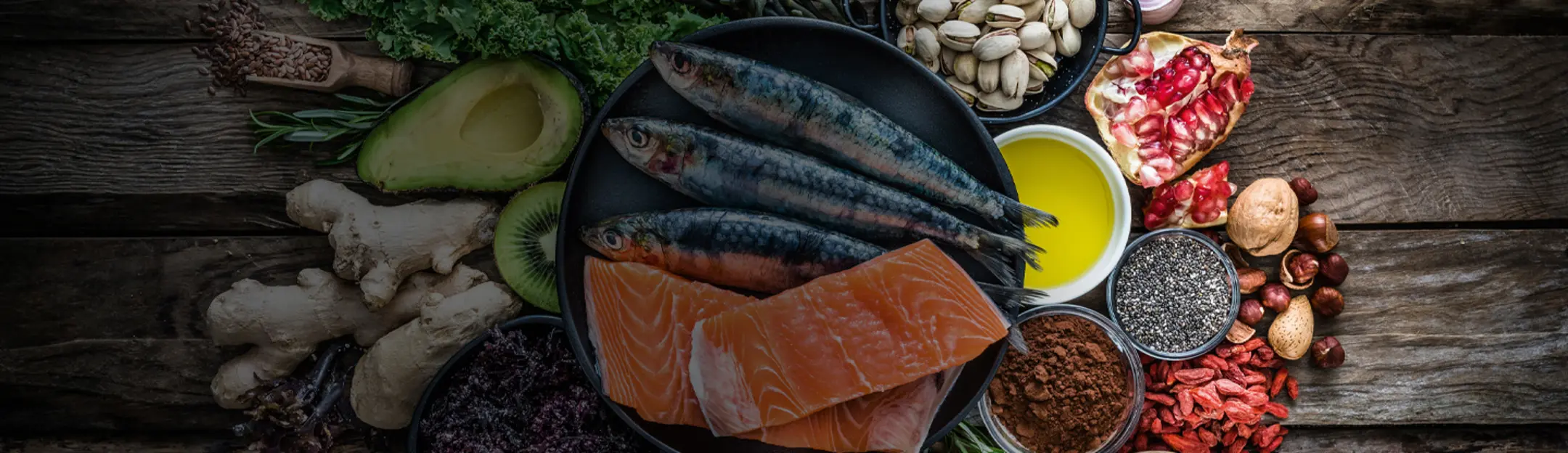 Arrangement aus gesunden Lebensmitteln wie Fisch, Nüsse, Obst und Geüse