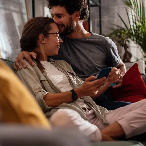 Lachendes junges Paar auf dem Sofa