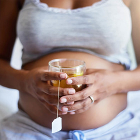 Nahaufnahme Schwangere hält Tee vor Bauch