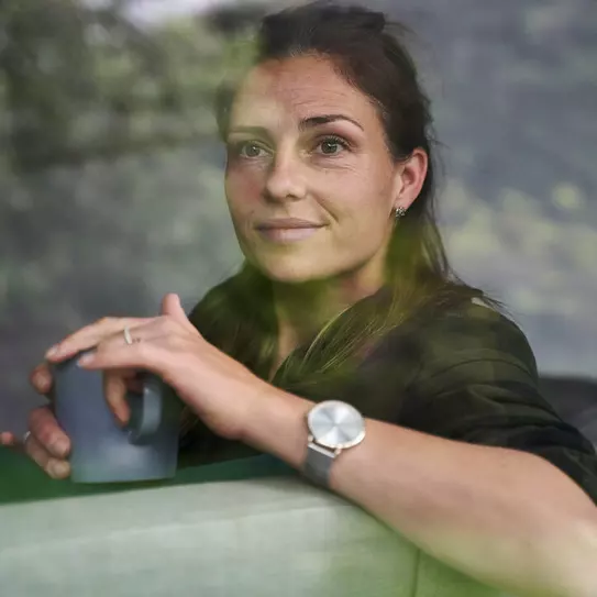 Frau hält Tasse Sicht durch Fenster