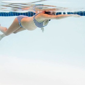 Schwangere Frau schwimmt