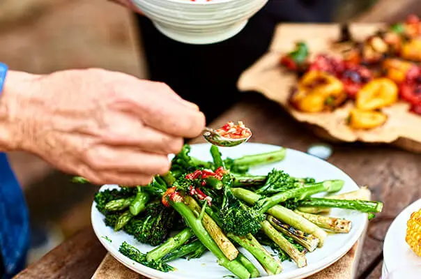 Chilliöl wird auf grünen Spargel geträufelt