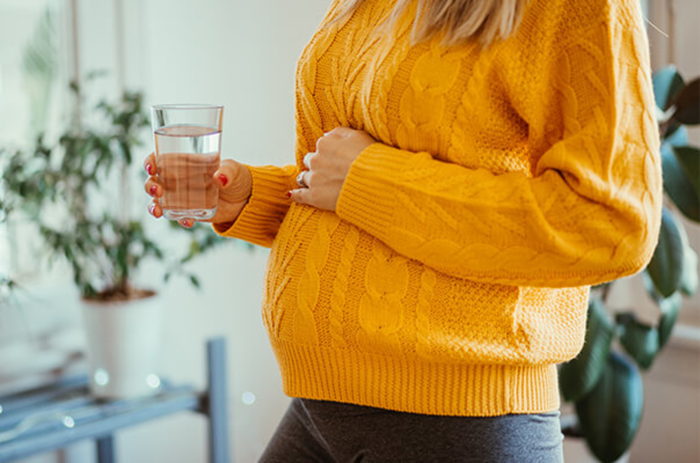 Schwangere Frau hält Wasserglas