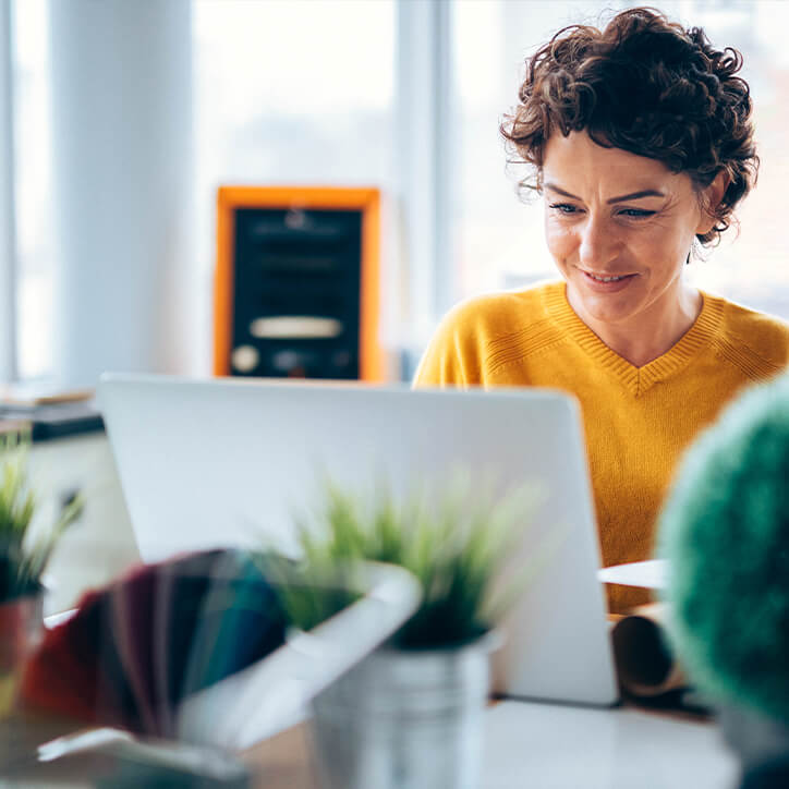 Frau sitzt vor Laptop