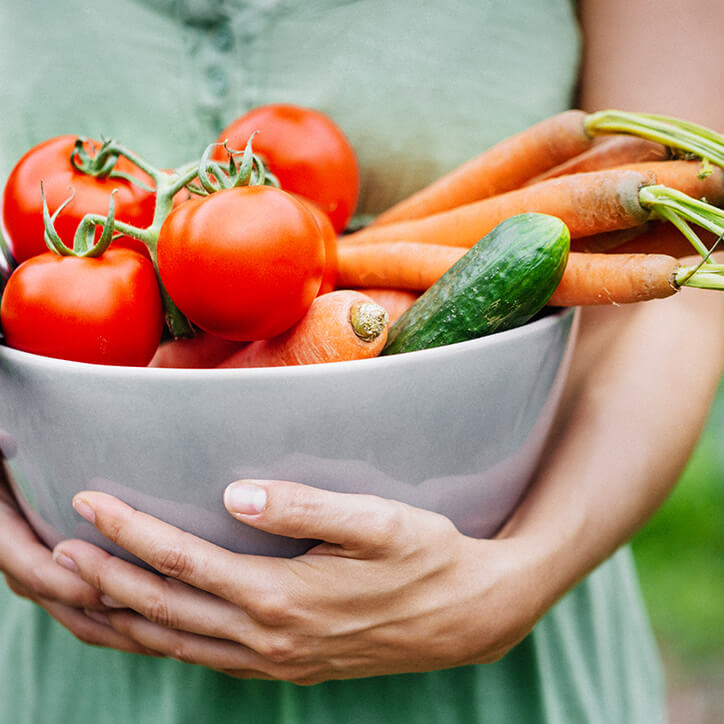 Frau trägt Schale mit frischen Obst