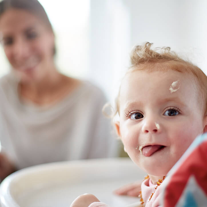 Baby mit Brei im Gesicht