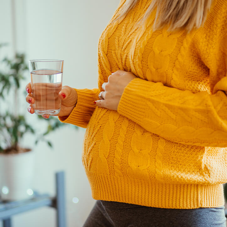 Schwangere hält Wasserglas
